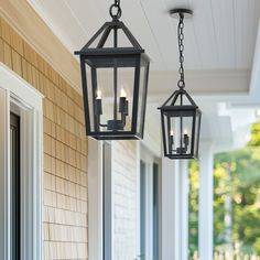 two lanterns hanging from the ceiling on a porch