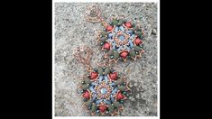 two necklaces made from beads and wire on the ground, one with a flower design