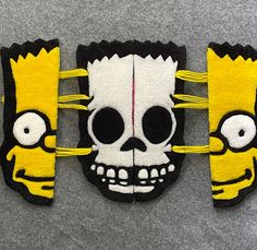 three pieces of felt with cartoon characters painted on them, one is yellow and the other is black