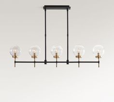 a chandelier with five glass globes hanging from it's black frame