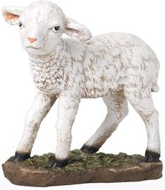 a white sheep figurine standing on top of a rock