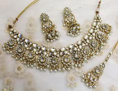 * Light weight gold white, marron necklace set studded with crystals. *Necklace Width- 2 inches *Earrings Length- 2.8 inches(included drops) *Earrings Breadth- 0.9 inches Festive White Jeweled Kundan Necklace, White Jeweled Kundan Necklace For Festivals, White Jeweled Kundan Necklace, White Kundan Jeweled Necklace, Nath Bridal, Indian Choker Necklace, Indian Nose Ring, Necklace Set Indian, Nose Rings Hoop