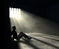 a person sitting on the floor in front of a window with light coming through it