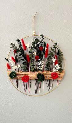 a wall hanging decoration with flowers and leaves on the side, made out of bamboo sticks