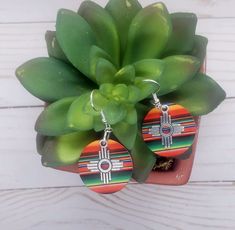 Zia Round Serape Earrings, New Mexico Serape Earrings, Southwestern Earrings, Western Earrings, Zia Jewelry, New Mexico Jewelry.  These lightweight earrings are perfect statement of the Southwest.  Earring is a lightweight wood printed with a vibrant serape print.  Final touch to adorn these precious earrings is a stainless-steel Zia charm.  These will for sure be your favorite earrings.  Perfect with any outfit and so light you won't even remember you are wearing them.  Get your today, they come in this multicolor serape print or check our page for other prints. Concho Dangle Earrings For Gift, Adjustable Concho Earrings For Festival, Southwestern Red Drop Earrings, Nickel-free Southwestern Red Earrings, Nickel-free Red Southwestern Earrings, Southwestern Style Red Nickel-free Earrings, Southwestern Multicolor Teardrop Earrings, Southwestern Multicolor Round Earrings, Southwestern Teardrop Concho Earrings