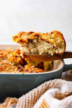 a casserole dish with meat and cheese being lifted from the casserole