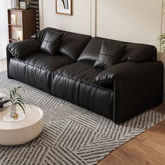 a black leather couch sitting on top of a rug