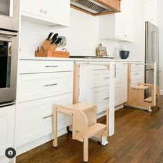 a kitchen with white cabinets and wood floors