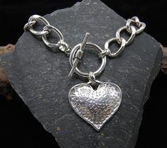 Silver Statement Heart Necklace, Large Silver Heart Necklace, Solid Silver Chain, Gift For Her, Chunky Silver Necklace, Heavy Toggle Clasp A real statement piece.  Hammered large statement heart pendant links with a chunky solid curb chain, with toggle clasp Great worn on its own or teamed with other pieces. All solid. Crafted from a zinc and brass alloy and plated in antique silver which is both hardwearing and durable. 925 Sterling Silver plated Zamak is a mix alloy of zinc aluminium magnesium Chunky Silver Necklace, Silver Heart Necklace, Toggle Clasp, Silver Heart, Heart Necklace, Heart Pendant, Favorite Jewelry, Antique Silver, Silver Chain