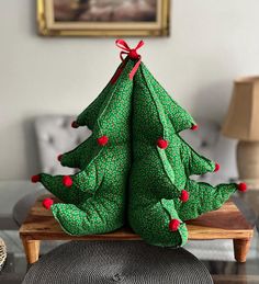 a green christmas tree sitting on top of a wooden table