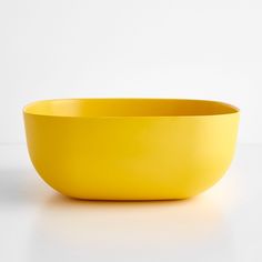 a yellow bowl sitting on top of a white table