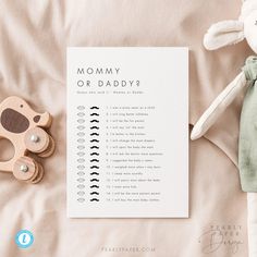 a baby's checklist with a wooden toy next to it on a bed