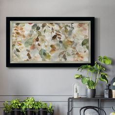 a painting hanging on the wall next to potted plants