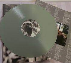 a record with an image of a woman's face on it, and two other records in the background