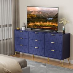 a flat screen tv sitting on top of a blue dresser