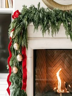 a fireplace decorated with christmas garland and ornaments