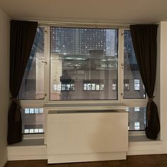 an empty room with large windows overlooking the city