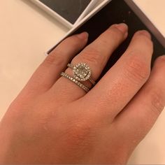 a woman's hand with two wedding rings on it