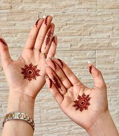 two hands with hendi designs on their palms