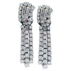 Pair of Art Deco Platinum Clip-on Earrings, accented with Round brilliant cut and Baguette cut Diamonds weighing together approximately 7.05 carats. G-H color, VS1-2 clarity. Step into the glamour of the Roaring Twenties with these exquisite Deco Platinum Clip-on Earrings. Each earring is adorned with a captivating array of round brilliant cut and Baguette cut diamonds, totaling approximately 7.05 carats. The diamonds, meticulously selected for their exceptional quality and brilliance, shimmer and sparkle with mesmerizing allure, capturing the essence of Art Deco glamour. Period: 1920-30s Style: Art Deco Metal: Platinum Stone: Diamonds Measurements: 1.83 x 0.47 inches. Stamped: No stamp. Total weight: 26.24 grams Condition: Very good.         - Free insured shipping  - 100% guarantee of fo 30s Style, Earring Video, The Roaring Twenties, 30s Fashion, Roaring Twenties, Baguette Cut Diamond, Art Deco Earrings, Art Deco Diamond, Pearl Diamond