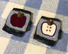 two crocheted apples sitting on top of a blue and white checkered table cloth