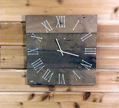 a wooden clock with roman numerals on the face is mounted on a wall