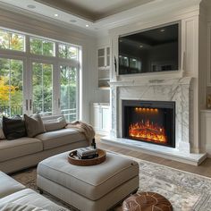 a living room filled with furniture and a fire place in front of a large window