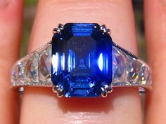 "A beautiful and elegant engagement ring, featuring custom-cut French Cut Classique Moissanites™ and your choice of a vintage-cut lab gemstone. The sample ring is shown with a 8x10mm antique asscher lab blue sapphire. This ring will be custom-made for you with your choice of vintage-style cut lab gemstone, including lab blue or pink sapphire, ruby, emerald or alexandrite. Please select the gemstone and cut/size in the pull-down menu. Or buy this listing as \"mount only\" and add another natural Classic Gia Certified Emerald Cut Sapphire Ring, Elegant Sapphire Ring With Vvs Clarity Cushion Cut, Exquisite Diamond-cut Sapphire Ring, Exquisite Sapphire Diamond Ring Gia Certified, Exquisite Diamond Cut Sapphire Ring, Exquisite Gia Certified Sapphire Diamond Ring, Classic Gia Certified Sapphire Ring, Vintage Gia Certified Sapphire Ring For Formal Occasions, Gia Certified Art Deco Sapphire Ring For Formal Occasions