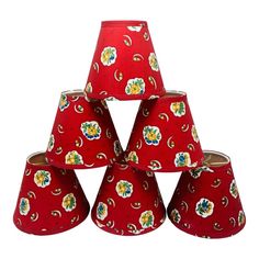 six red lampshades with flowers on them are stacked in the shape of a pyramid