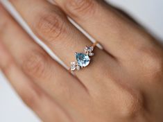 a woman's hand with an engagement ring on it and two pear shaped diamonds