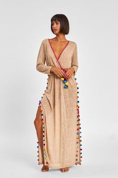 Inspired by the romantic Greek Island Santorini, this dress features a plunging neckline, an elasticated waistband and side slits adorned by multicolored pom poms. The Inca trim and larger multicolored pompoms make up a detachable belt. Please note that this is a sheer burnout fabric. If you prefer more coverage, take a look at our Pima styles! *Due to monitor differences, actual colors may vary slightly from what appears online* Tan Maxi Dress, Santorini Dress, Summer Elegance, Burnout Fabric, Fits For Summer, Summer Beach Dress, Greek Island, Beachwear For Women, Clothing Size Chart