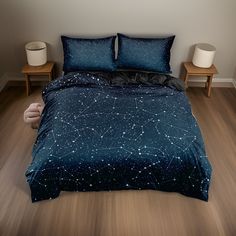 there is a bed with stars on it and two night stands next to the bed