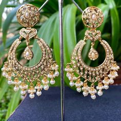 A pair of chandbali earrings in 925 silver with gold plating. Metal: 92.5% silver Setting stones: Real freshwater pearls Beads: Real freshwater pearls Weight - 30 GMs Height - 7.8 cm Width- 3.75 cm Jadau Chandbali Earrings, Pearl Drop Earrings For Reception, Traditional White Pearl Earrings For Reception, White Pearl Earrings For Reception, Bollywood Pearl Drop Earrings For Reception, Traditional Pearl Drop Earrings For Reception, Gold Pearl Drop Earrings For Reception, Traditional Pearl Embellished Earrings, Pearl Bridal Earrings With Meenakari For Celebration