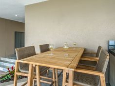 a wooden table and chairs with wine glasses on it