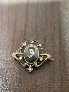 "Vintage Edwardian Portrait Brooch/pin, Sweetheart Brooch, Love Token, Mourning Pin, Gold Filled with Pearls, Tinted Photo of a Young Man This brooch measures approximately 1.5 x 1.25 inches. The metal is not marked, but it looks like it could be gold filled. It is signed \"SD.\" The photo frame is an art nouveau design that has tiny pearls. The photo in the brooch frame is the face of a young man. The man has a heavy mustache,  and the image has been tinted. The brooch closure on back is a foldover c clasp with a hinged pin.  Ships only to US  Sold as is  No Refunds or Exchanges  NYW23" Vintage Enamel Brooch Pin For Anniversary, Antique Wedding Lapel Pin, Victorian Brooch Pins For Wedding, Antique Heart Brooch For Wedding, Victorian Style Wedding Brooch Enamel Pin, Vintage Brooch Pins For Anniversary, Victorian Wedding Enamel Brooch Pin, Antique Wedding Lapel Pin Brooch, Victorian Style Wedding Enamel Brooch Pin