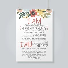 a poster with the words i am and an image of flowers on it, hanging from hooks