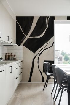 a black and white painting on the wall in a kitchen