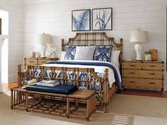 a bamboo bed frame with blue and white pillows on top of it in a bedroom