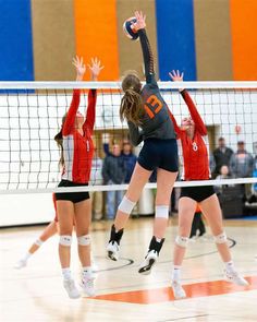 the volleyball players are trying to hit the ball