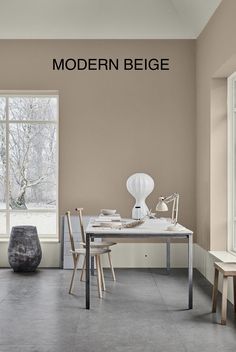 an empty room with a table and chairs in front of a window that reads modern beige