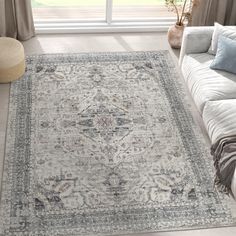 a living room area with a couch, rug and window