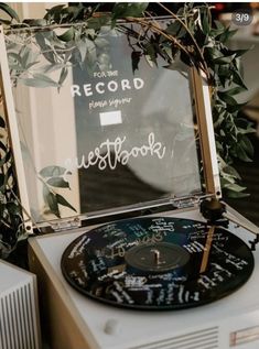 a record player sitting on top of a table next to a sign that says guestbook