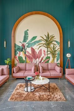 a living room with pink couches and green walls