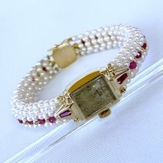 Beautiful One of A Kind stunning vintage working Winding Dial Watch is reworked into a timeless and elegant Pearl, Ruby and 14k Yellow Gold piece. Stamped and made in all solid 14k Yellow Gold, this timeless watch is revived by Tapered Baguette Rubies set on each side which perfectly contrasts the 14k Yellow Gold. A stunning band of round white Seed Pearls, Faceted Rubies and solid 14k Yellow Gold findings are all intricately woven together to frame this vintage piece. This top of the band is wo Luxury Wedding Jewelry And Watches With Jubilee Bracelet, Luxury Jubilee Bracelet Jewelry For Wedding, Luxury Jubilee Bracelet For Wedding, Timeless Yellow Gold Wedding Jewelry And Watches, Wedding Jewelry With Diamond Hour Markers, Timeless Yellow Gold Jewelry For Wedding, Yellow Gold Jewelry For Wedding, Yellow Gold Diamond Watch With 17 Jewels For Wedding, Evening Yellow Gold Jewelry With Box Clasp