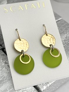 "The round link is plated with glossy 18K gold . The finish is glossy because it is rack plated. This means that the pieces are hand hung so they receive the optimal amount of coverage. Hanging from the link is a sea glass round drop with 18K gold barrel plated rings. The sea glass comes in five different colors as follows: 1) Lime Green 2) Turquoise 3) Teal 4) Mint Green 5) Navy The earrings are lead safe. The ear wires are 16 K gold plated with rubber back stoppers. The full length of the earr Elegant Green Circular Earrings, Modern Green Circular Jewelry, Nickel Free Round Green Earrings, Nickel-free Green Round Earrings, Green Nickel-free Round Earrings, Green Round Earrings, Modern Green Round Earrings, Elegant Gold Round Disc Earrings, Green Dangle Earrings Cadmium-free