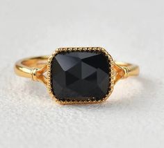 a gold ring with a black stone on it