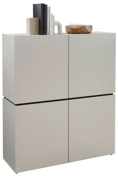 a white cabinet with some books and a bowl on it's top, against a white background