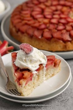 a slice of strawberry shortcake with whipped cream on top and strawberries in the background