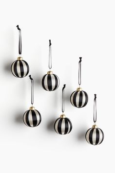 six black and white ornaments hanging from strings