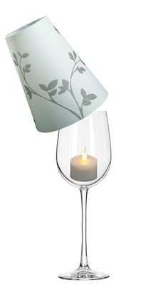 a candle is lit in a wine glass with a lamp on the top and bottom